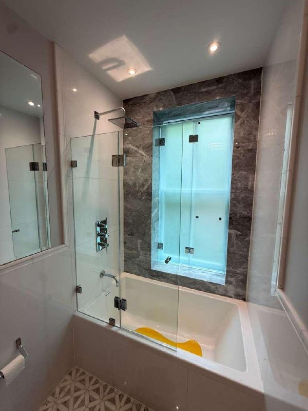 Frosted glass window protection with a hinged tub shower door in a Monticello bathroom